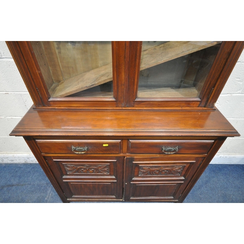 1262 - AN EDWARDIAN MAHOGANY BOOKCASE, with a scrolled crest, the double glazed doors, enclosing three shel... 