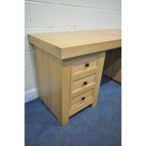 1281 - A HEAVY SOLID OAK DESK, with three drawers and dummy drawer enclosing a cupboard to fit a tower comp... 