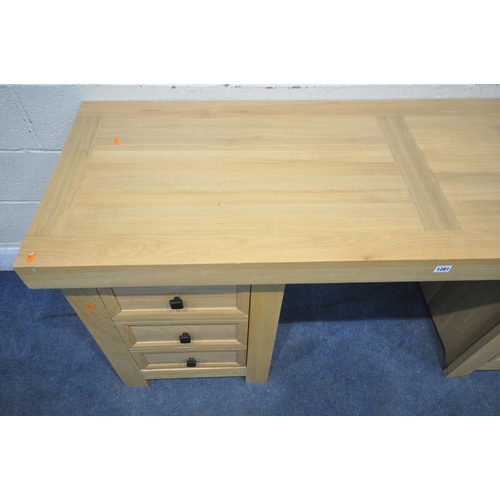 1281 - A HEAVY SOLID OAK DESK, with three drawers and dummy drawer enclosing a cupboard to fit a tower comp... 