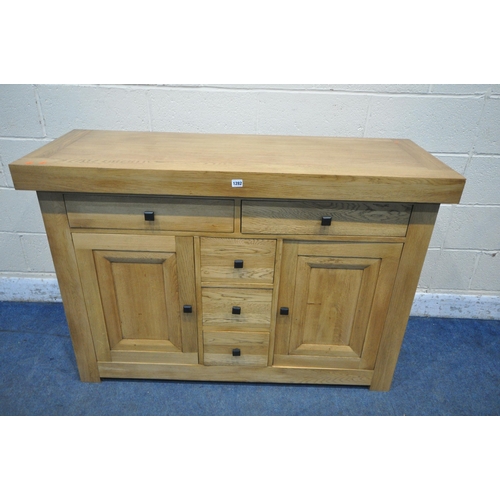 1282 - A HEAVY SOLID OAK SIDEBOARD, with a deep top, fitted with five drawers and double cupboard doors, wi... 