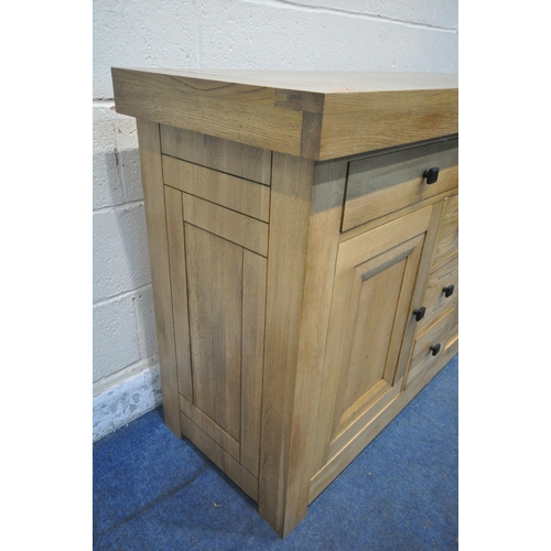 1282 - A HEAVY SOLID OAK SIDEBOARD, with a deep top, fitted with five drawers and double cupboard doors, wi... 