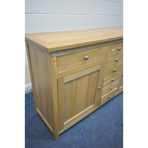 1283 - A SOLID OAK SIDEBOARD, with eight drawers, and two cupboard doors, width 169cm x depth 47cm x height... 