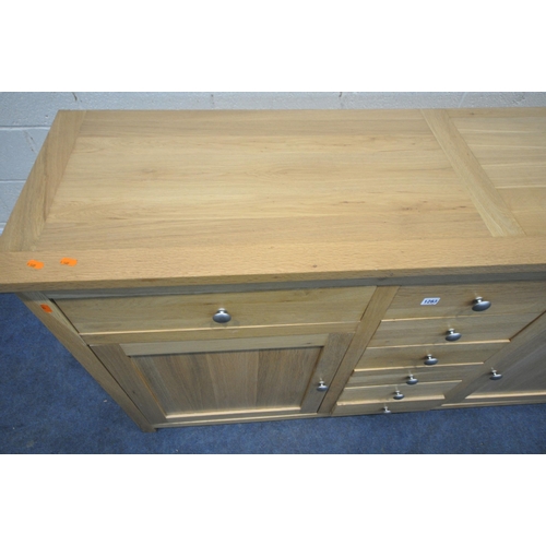 1283 - A SOLID OAK SIDEBOARD, with eight drawers, and two cupboard doors, width 169cm x depth 47cm x height... 