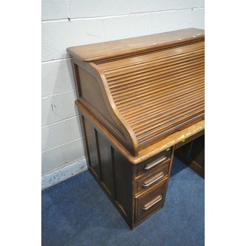 1311 - ANGUS OF LONDON, AN EARLY  20TH CENTURY OAK ROLL TOP DESK, with a fitted interior, two brushing slid... 