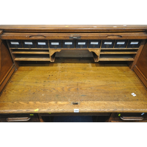 1311 - ANGUS OF LONDON, AN EARLY  20TH CENTURY OAK ROLL TOP DESK, with a fitted interior, two brushing slid... 