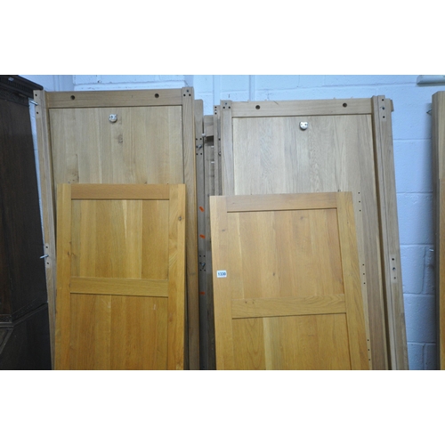 1330 - A SOLID OAK PANELLED WARDROBE, with double panelled doors, flanking a revolving mirror, with an arra... 