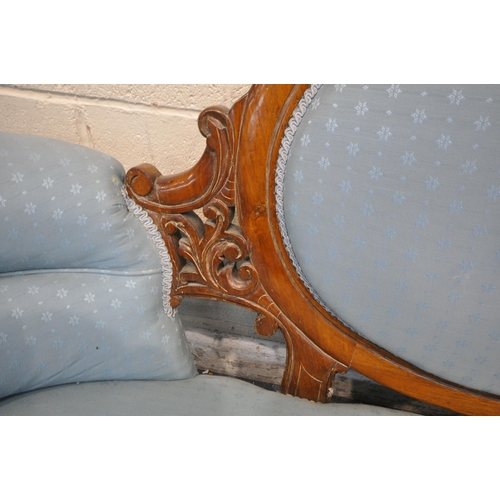 1352 - A LATE VICTORIAN WALNUT SOFA, with an oval backrest, open carving, and patterned blue upholstery, wi... 