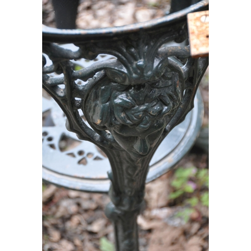 1004 - A GREEN PAINTED CAST IRON PUB TABLE BASE, the two ends united by a cross stretcher, a cast iron circ... 