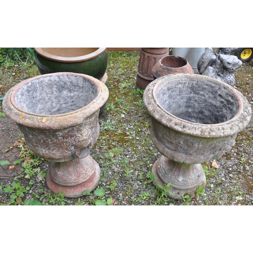 1005 - A PAIR OF LATE 20TH CENTURY COMPOSITE GARDEN URNS, the top with lion mask decoration, atop a tapered... 