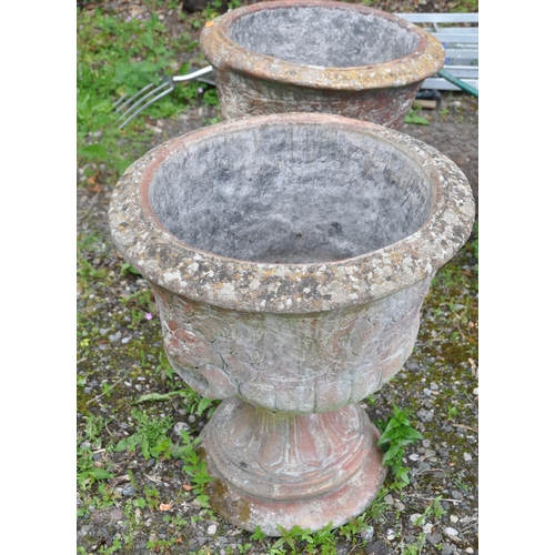 1005 - A PAIR OF LATE 20TH CENTURY COMPOSITE GARDEN URNS, the top with lion mask decoration, atop a tapered... 