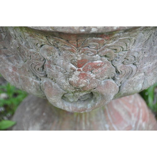 1005 - A PAIR OF LATE 20TH CENTURY COMPOSITE GARDEN URNS, the top with lion mask decoration, atop a tapered... 