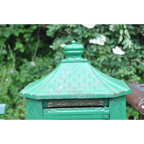 1014 - A GREEN PAINTED CAST IRON LETTER BOX, the door depicting a horse and jockey, raised on a cylindrical... 