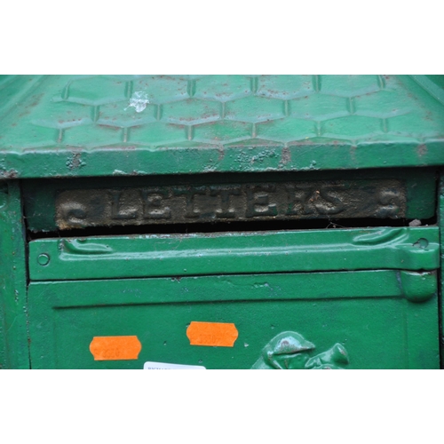 1014 - A GREEN PAINTED CAST IRON LETTER BOX, the door depicting a horse and jockey, raised on a cylindrical... 