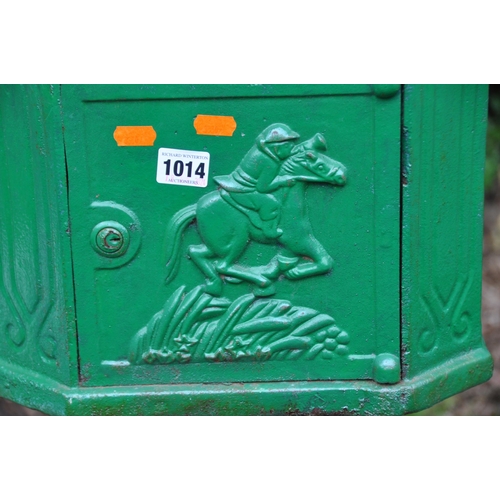 1014 - A GREEN PAINTED CAST IRON LETTER BOX, the door depicting a horse and jockey, raised on a cylindrical... 