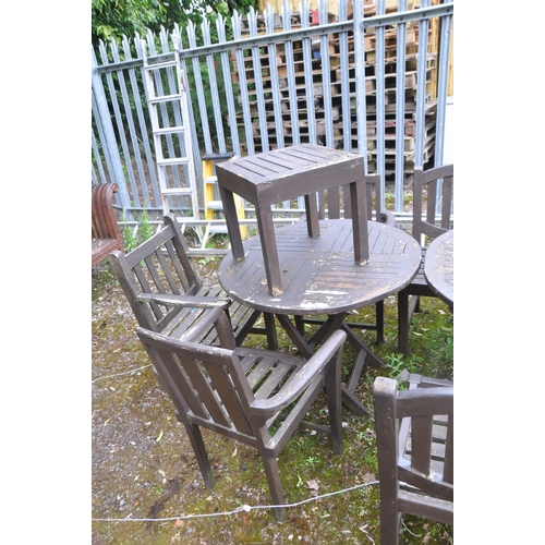 1017 - A STAINED TEAK OVAL EXTENDING GARDEN TABLE, a smaller circular folding table, a set of four chairs a... 