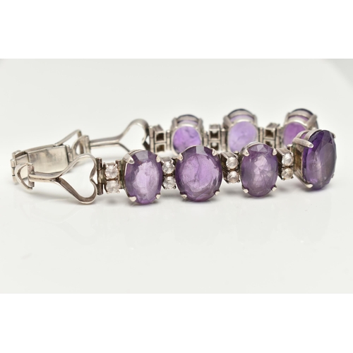 30 - AN AMETHYST BRACELET, designed as a graduated line of oval amethysts, each interspaced by two circul... 