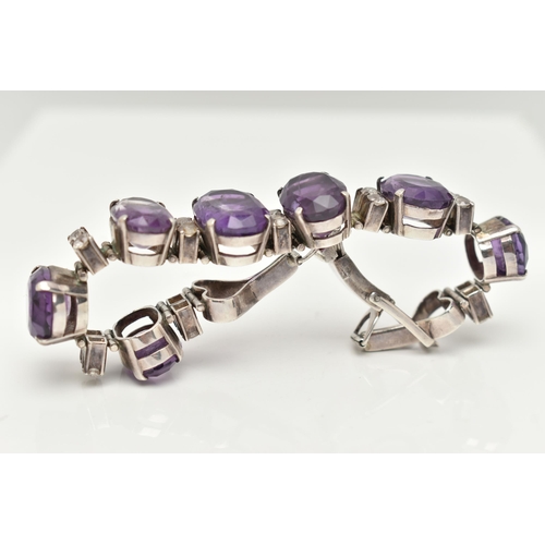 30 - AN AMETHYST BRACELET, designed as a graduated line of oval amethysts, each interspaced by two circul... 