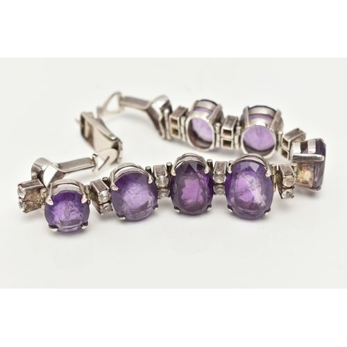 30 - AN AMETHYST BRACELET, designed as a graduated line of oval amethysts, each interspaced by two circul... 