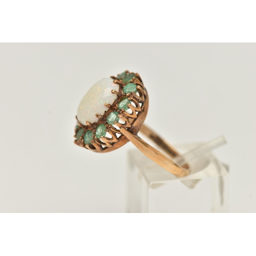 9 - A 9CT GOLD OPAL AND EMERALD RING, a cabochon oval opal, prong set with a surround of circular cut em... 