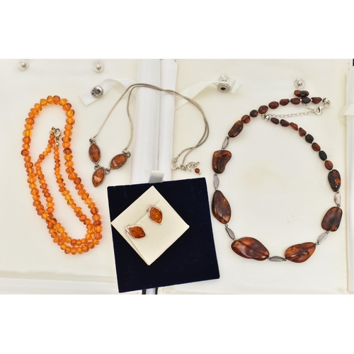 100 - FOUR ITEMS OF JEWELLERY, to include an amber polished pebble necklace, an amber polished bead neckla... 