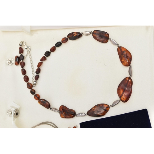 100 - FOUR ITEMS OF JEWELLERY, to include an amber polished pebble necklace, an amber polished bead neckla... 