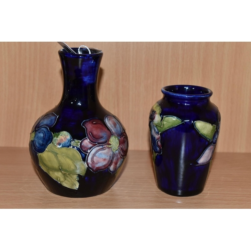 328 - TWO MOORCROFT POTTERY BUD VASES, comprising a Clematis pattern on cobalt blue ground bulbous vase, h... 