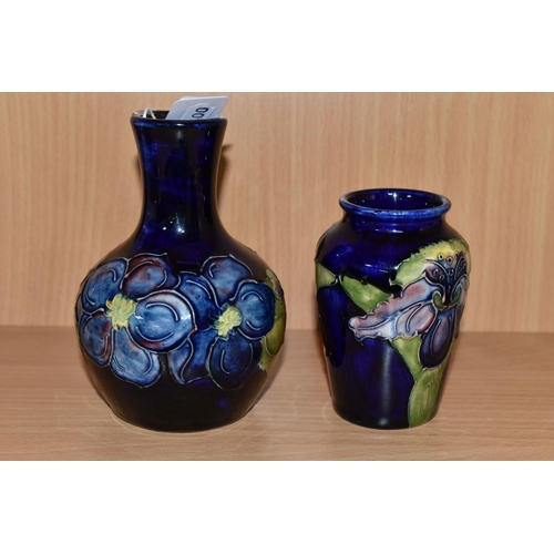 328 - TWO MOORCROFT POTTERY BUD VASES, comprising a Clematis pattern on cobalt blue ground bulbous vase, h... 