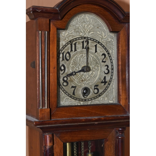 354 - A MANTEL CLOCK IN THE FORM OF A GRANDFATHER CLOCK, with black Arabic numerals on a painted metal dia... 