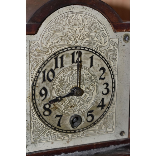 354 - A MANTEL CLOCK IN THE FORM OF A GRANDFATHER CLOCK, with black Arabic numerals on a painted metal dia... 