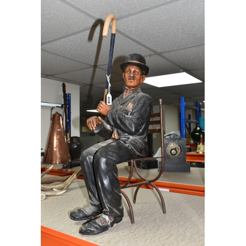 418 - A SEATED CHARLIE CHAPLIN FIGURE seated on a metal chair carrying a cane, approximately 56cm high (Co... 