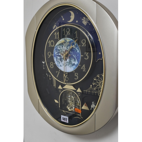 507 - A MUSICAL MOVING 'SMALL WORLD RHYTHM' WALL CLOCK, circus themed, the dial with an image of the Earth... 