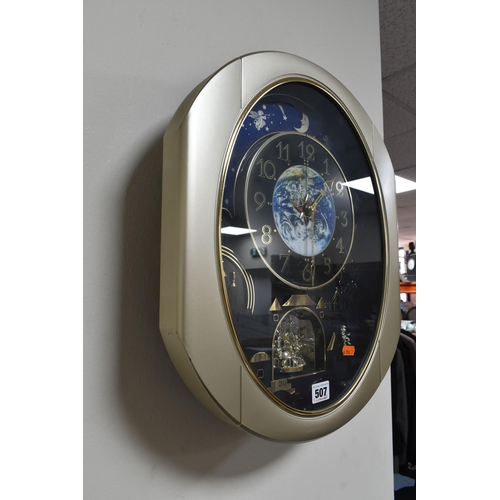 507 - A MUSICAL MOVING 'SMALL WORLD RHYTHM' WALL CLOCK, circus themed, the dial with an image of the Earth... 