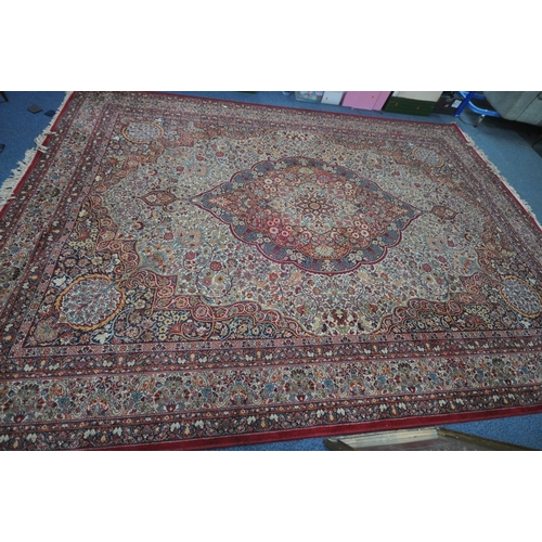 1372 - A PRADO ORIENT MACHINE WOVEN RED PATTERNED RUG, with a repeating pattern, central medallion and mult... 