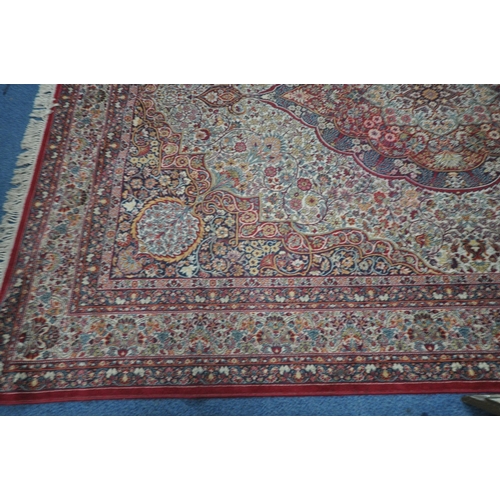 1372 - A PRADO ORIENT MACHINE WOVEN RED PATTERNED RUG, with a repeating pattern, central medallion and mult... 