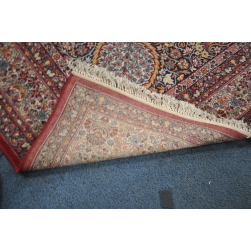 1372 - A PRADO ORIENT MACHINE WOVEN RED PATTERNED RUG, with a repeating pattern, central medallion and mult... 