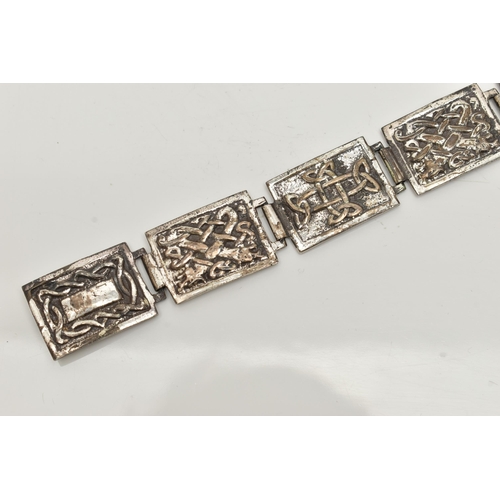 29 - A SILVER CELTIC ARTICULATED BRACELET, designed as a series of seven rectangular panels each with a C... 