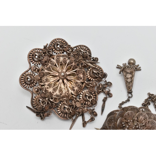 35 - FOUR ITEMS OF JEWELLERY, to include a white metal filigree flower brooch with two tassels, fitted wi... 