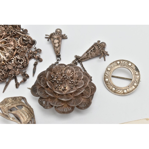 35 - FOUR ITEMS OF JEWELLERY, to include a white metal filigree flower brooch with two tassels, fitted wi... 