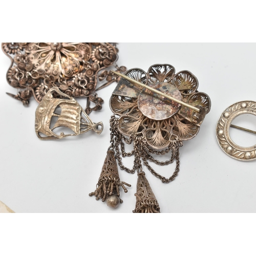 35 - FOUR ITEMS OF JEWELLERY, to include a white metal filigree flower brooch with two tassels, fitted wi... 