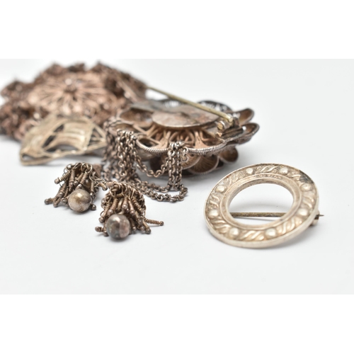 35 - FOUR ITEMS OF JEWELLERY, to include a white metal filigree flower brooch with two tassels, fitted wi... 