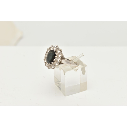 43 - A 9CT WHITE GOLD CLUSTER RING, of an oval design, set to the centre with a deep blue oval cut sapphi... 