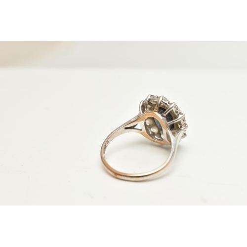 43 - A 9CT WHITE GOLD CLUSTER RING, of an oval design, set to the centre with a deep blue oval cut sapphi... 