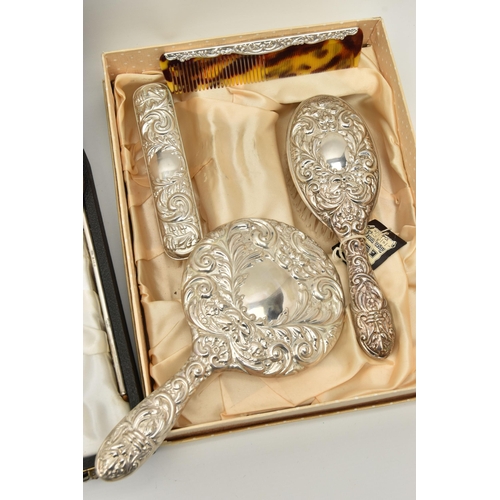 124 - TWO BOXED SILVER VANITY SETS AND TWO SILVER PHOTO FRAMES, the vanity set comprising of a hair brush,... 