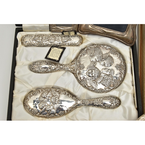 124 - TWO BOXED SILVER VANITY SETS AND TWO SILVER PHOTO FRAMES, the vanity set comprising of a hair brush,... 