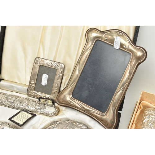 124 - TWO BOXED SILVER VANITY SETS AND TWO SILVER PHOTO FRAMES, the vanity set comprising of a hair brush,... 