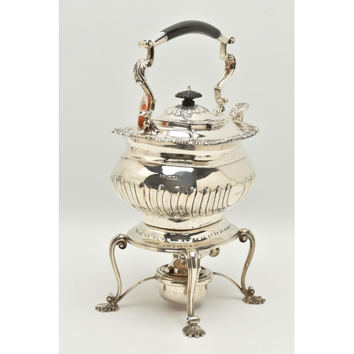 140 - A GEORGE V SILVER SPIRIT KETTLE ON STAND OF SHAPED RECTANGULAR FORM, of George IV style, foliate cas... 