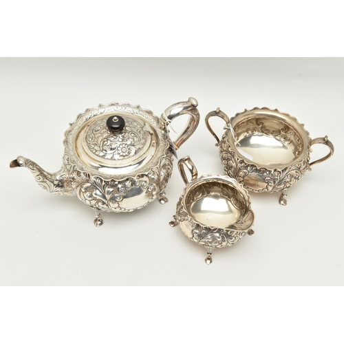 145 - A LATE VICTORIAN SILVER THREE PIECE TEA SET OF CIRCULAR FORM WITH WAVY RIMS, ornately cast with foli... 