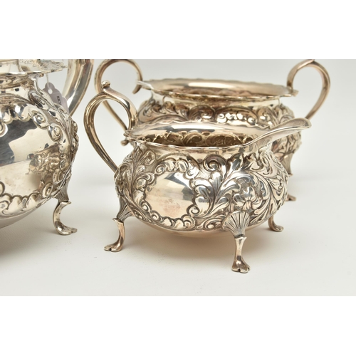 145 - A LATE VICTORIAN SILVER THREE PIECE TEA SET OF CIRCULAR FORM WITH WAVY RIMS, ornately cast with foli... 