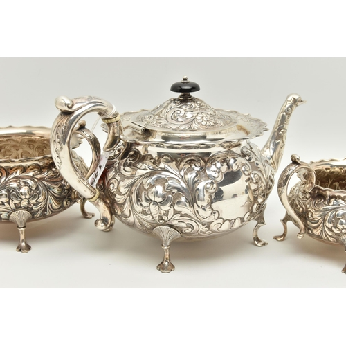 145 - A LATE VICTORIAN SILVER THREE PIECE TEA SET OF CIRCULAR FORM WITH WAVY RIMS, ornately cast with foli... 