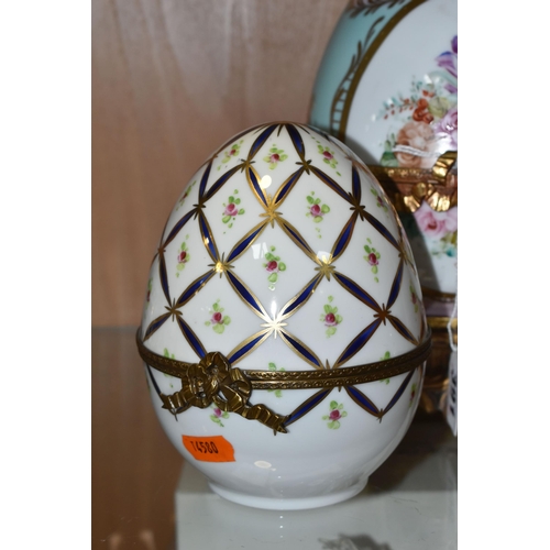 391 - TWO LIMOGES PORCELAIN DECORATED EGGS, the larger egg on a gilt metal base is painted with flowers on... 